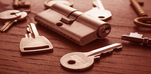 A keyhole and a bunch of different keys on a surface