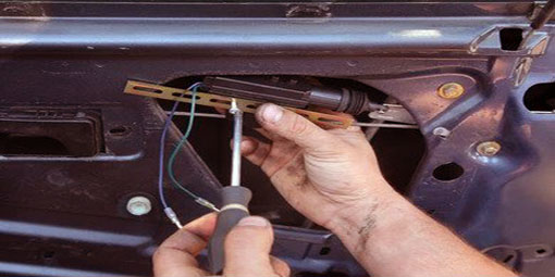 Someone inserting or removing a screw to replace the locks of a car 